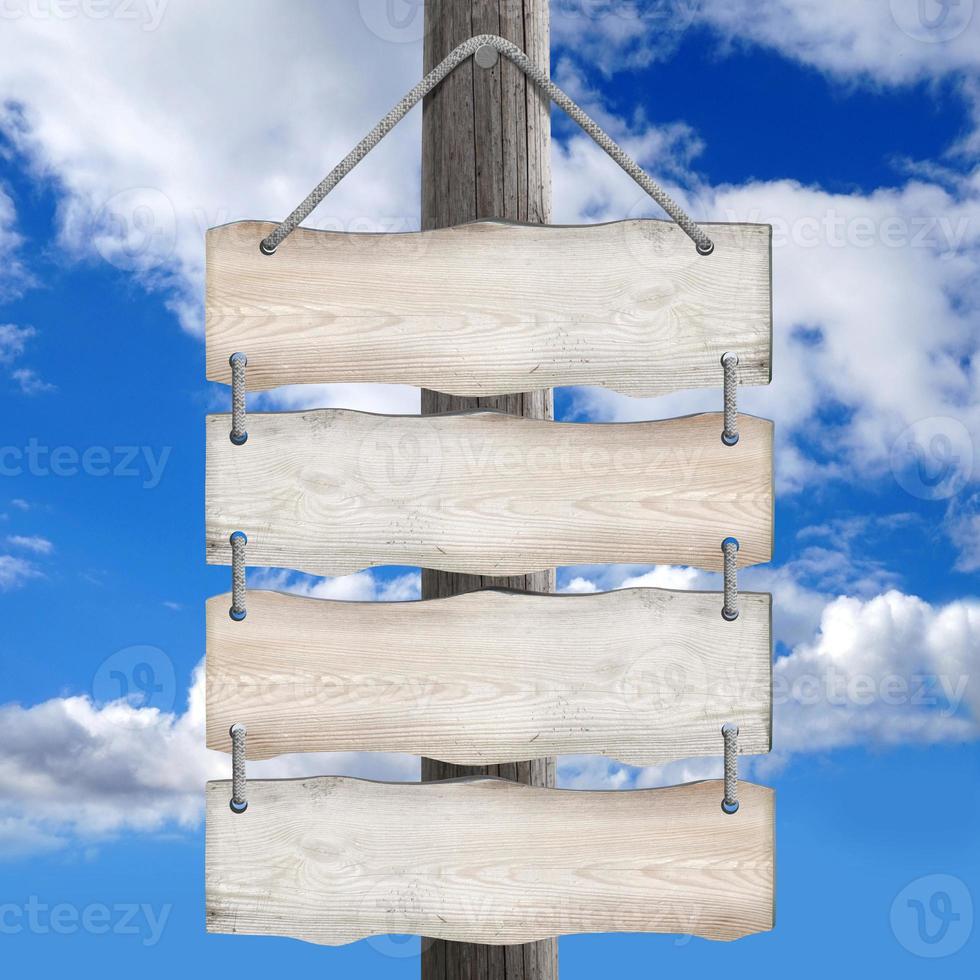 Four Boards Hanging on Post on Ropes with Sky in Background photo
