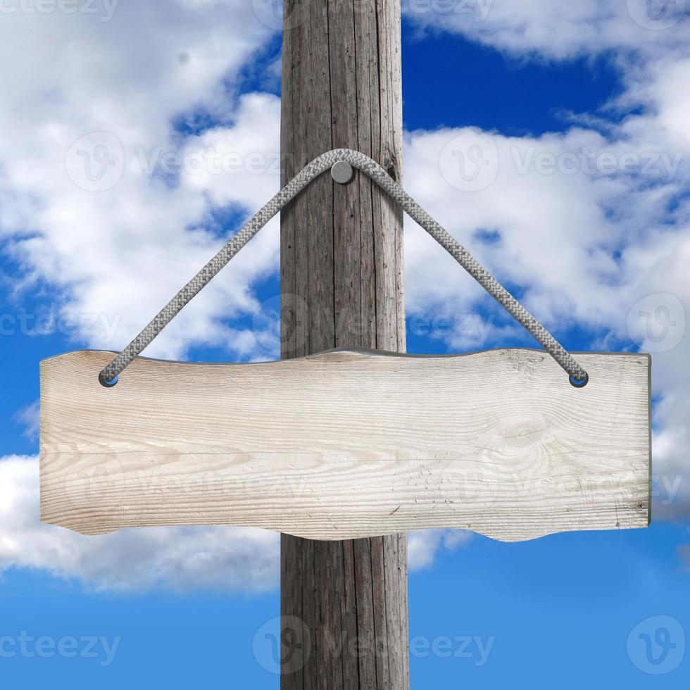 Wooden Board Hanging on Post on A Rope with Sky in Background photo