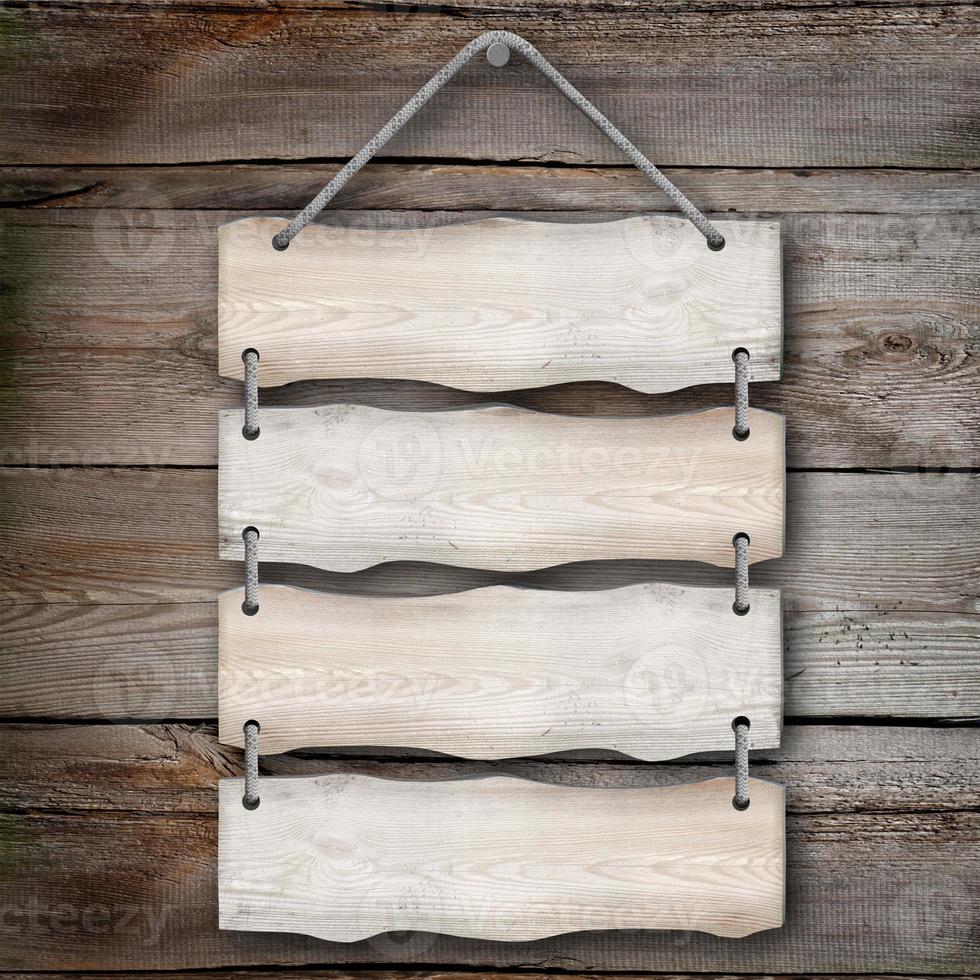 Four Wooden Boards Hanging on A Rope with Wood in Background photo