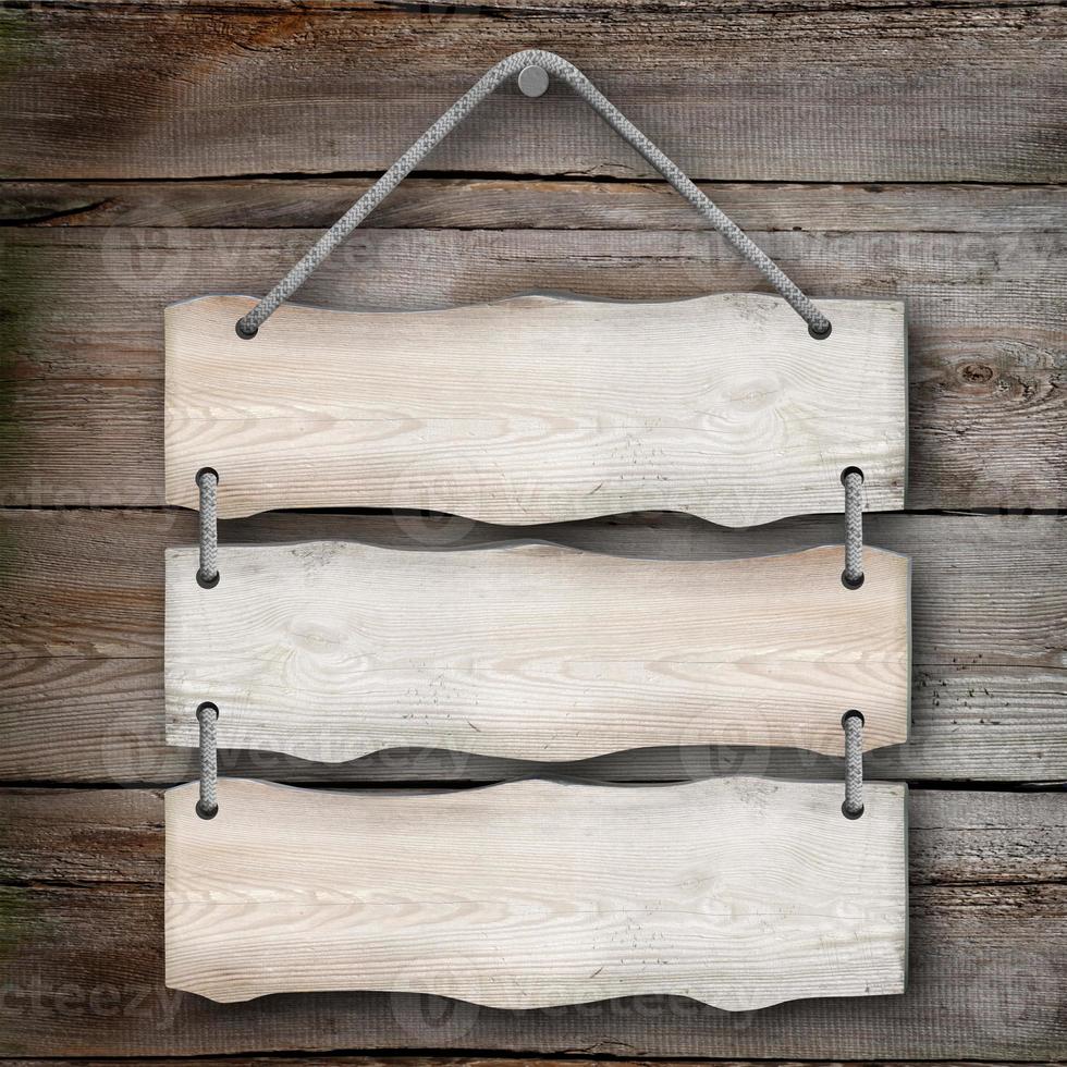 Three Wooden Boards Hanging on A Rope with Wood in Background photo
