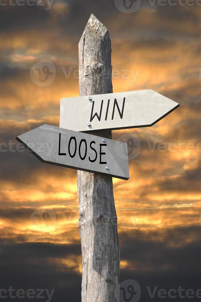 Win or Loose - Wooden Signpost with Two Arrows and Sunset Sky photo