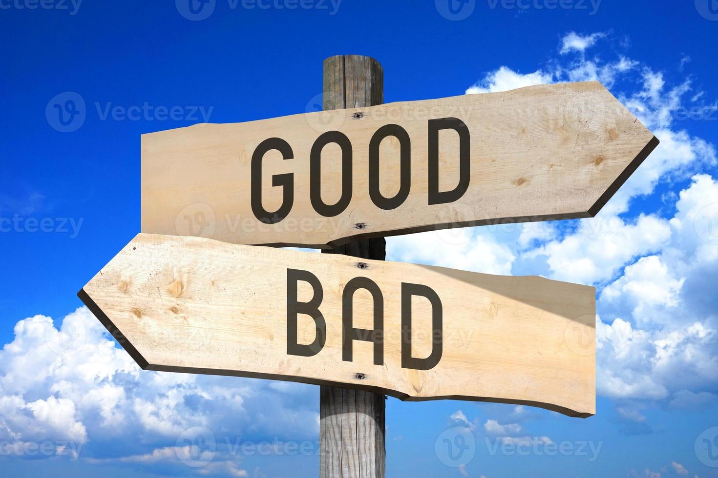 Good, Bad - Wooden Signpost with Two Arrows, Sky with Clouds in Background photo