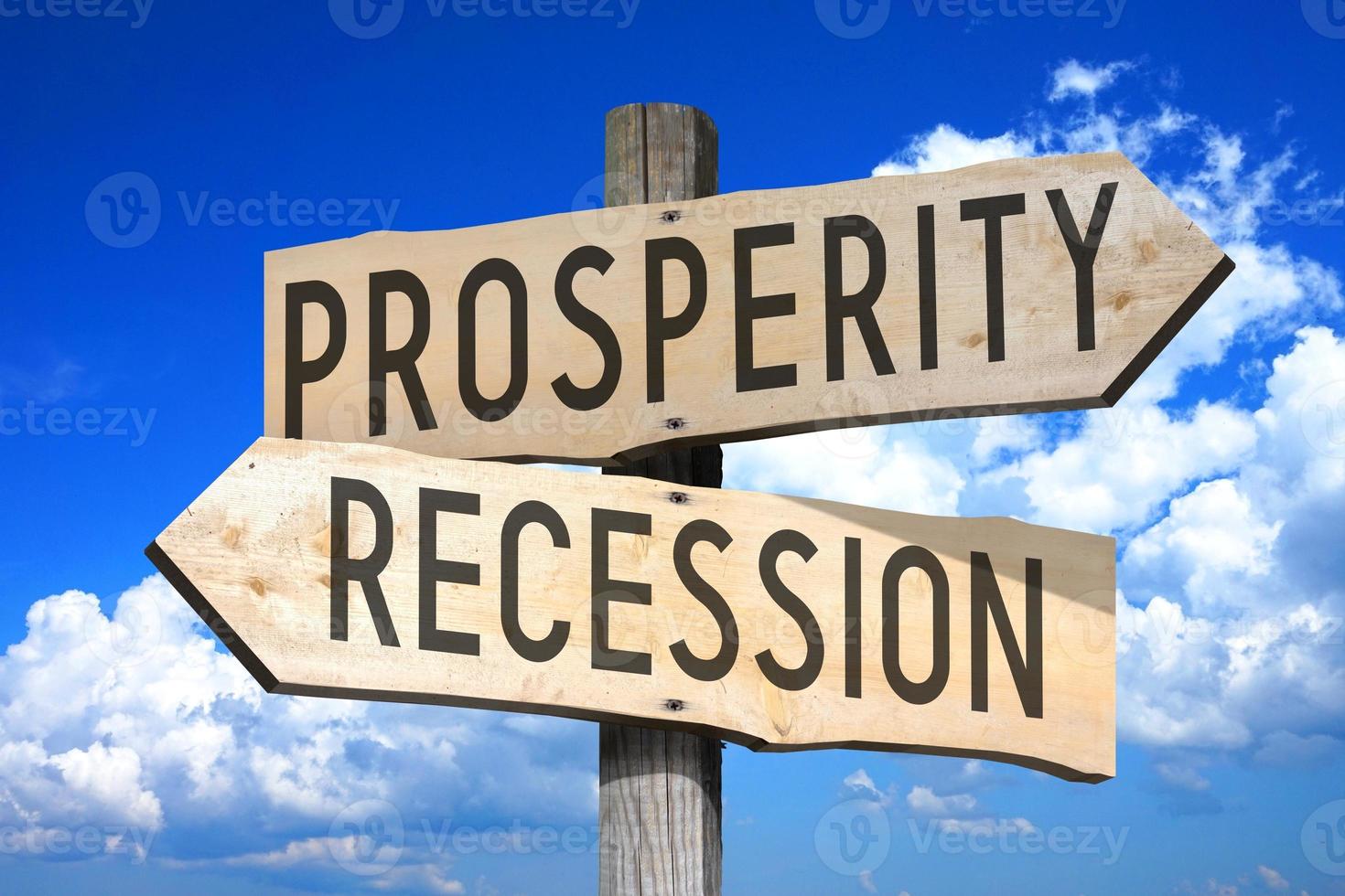 Prosperity, Recession - Wooden Signpost with Two Arrows, Sky with Clouds in Background photo