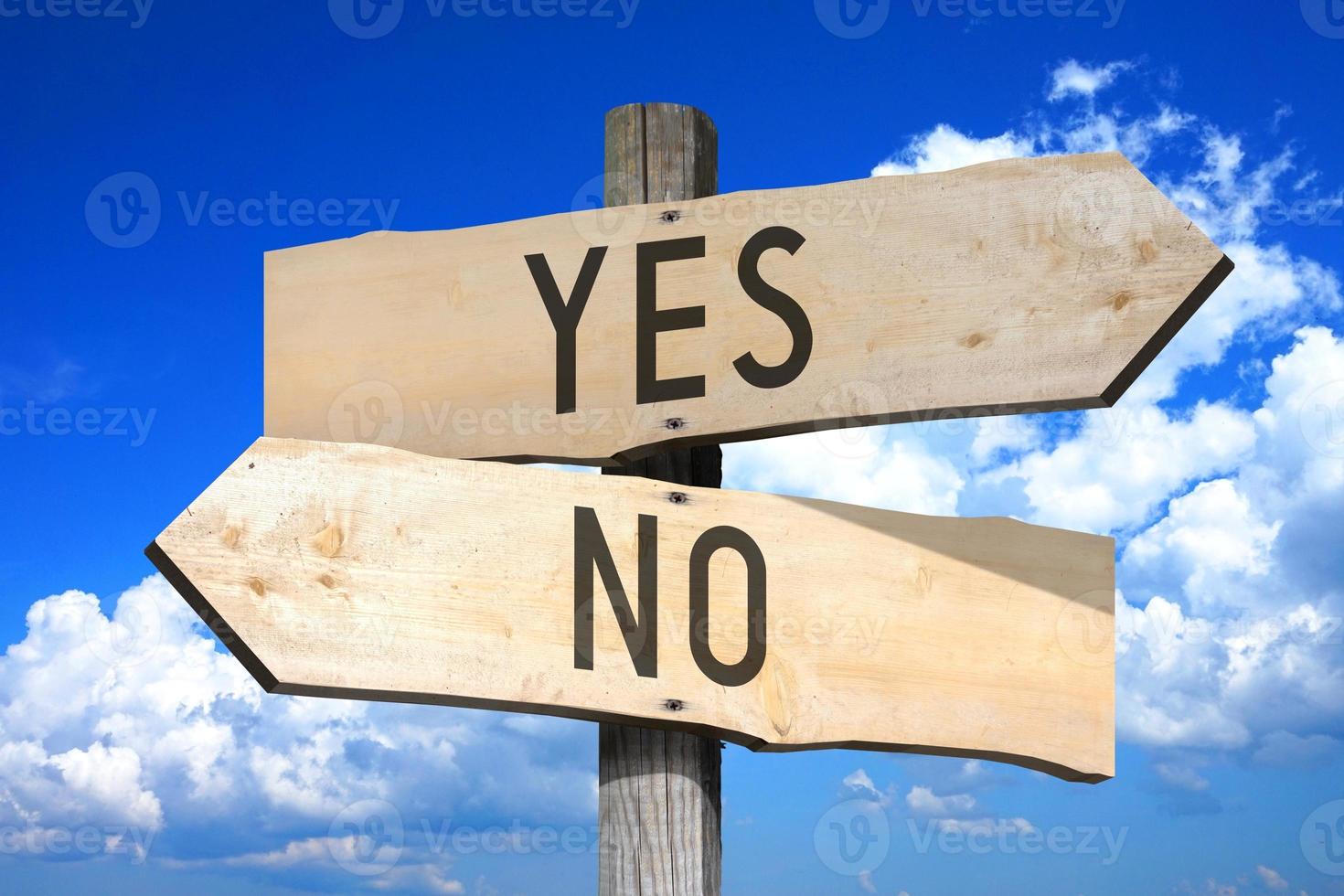 Yes, No - Wooden Signpost with Two Arrows, Sky with Clouds in Background photo