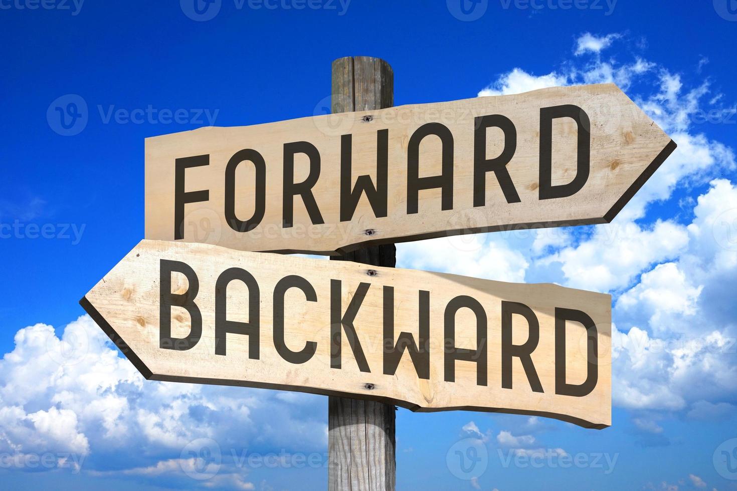 Forward, Backward - Wooden Signpost with Two Arrows, Sky with Clouds in Background photo