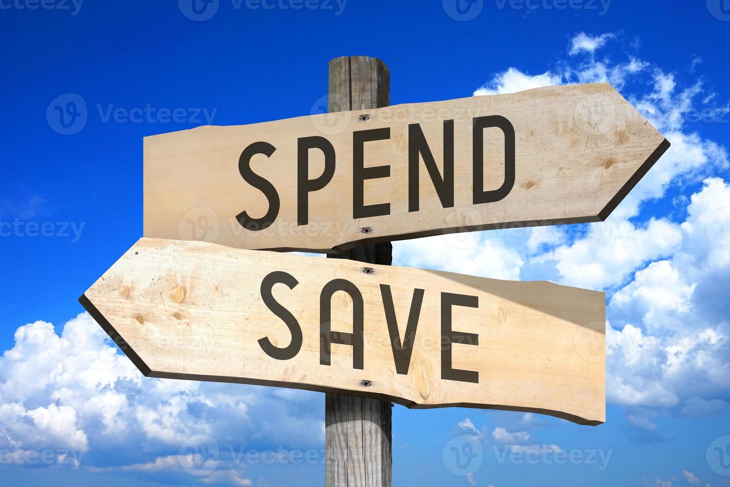 Spend, Save - Wooden Signpost with Two Arrows, Sky with Clouds in Background photo