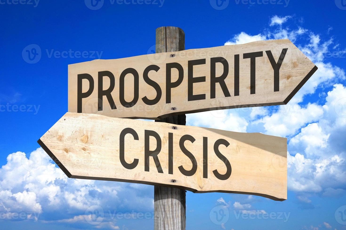 Prosperity, Crisis - Wooden Signpost with Two Arrows, Sky with Clouds in Background photo