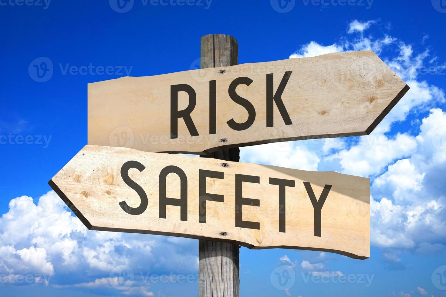 Risk, Safety - Wooden Signpost with Two Arrows, Sky with Clouds in Background photo