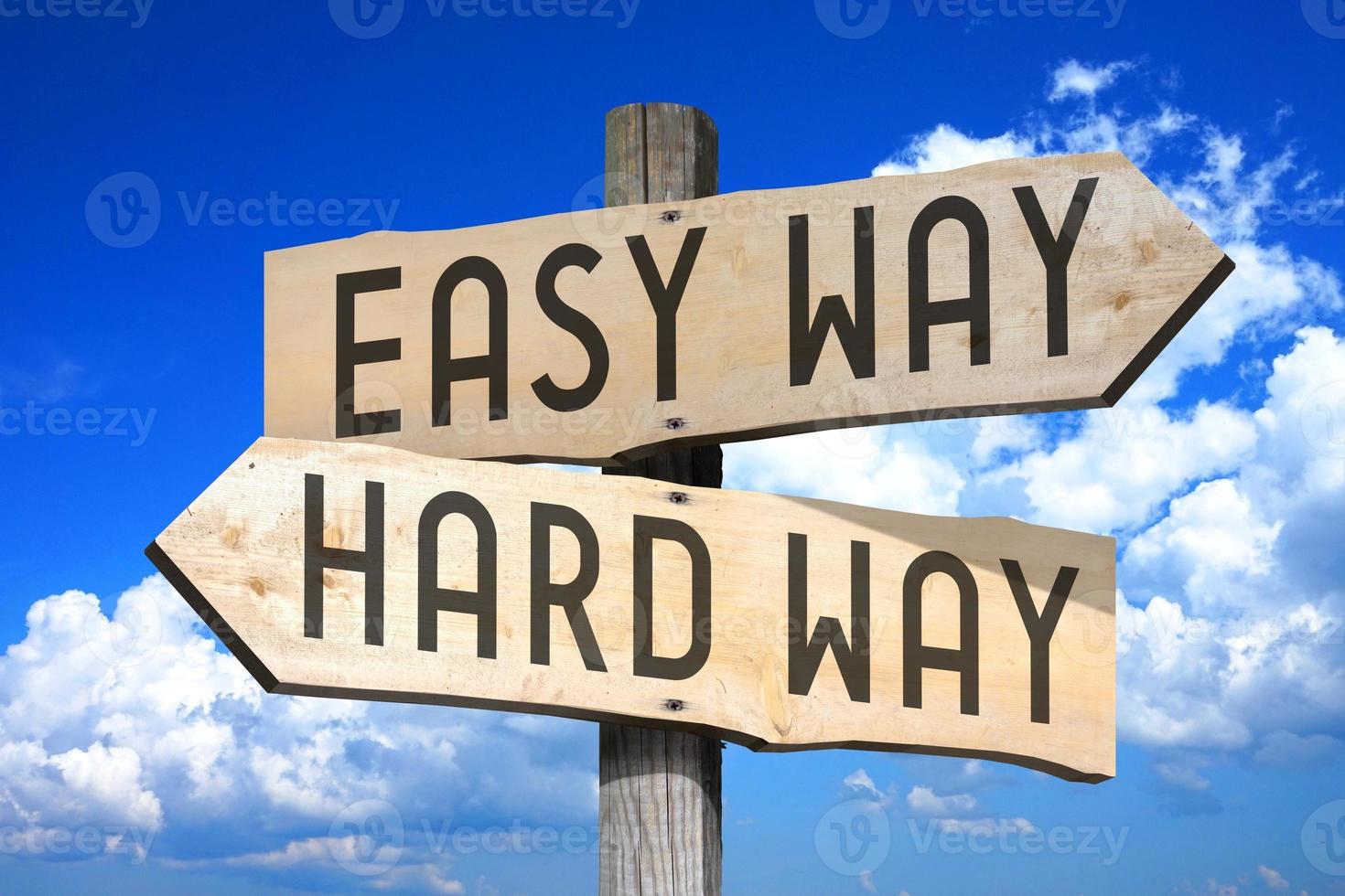 Easy Way, Hard Way - Wooden Signpost with Two Arrows, Sky with Clouds in Background photo