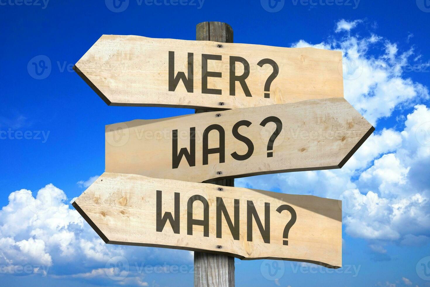 Questions in German - Wooden Signpost with Three Arrows, Sky with Clouds in Background photo