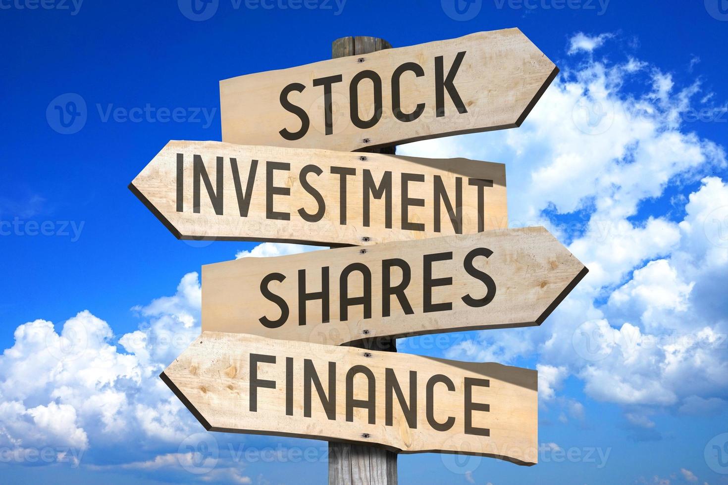 Stock, investment, Shares, Finance - Wooden Signpost with Four Arrows, Sky with Clouds in Background photo