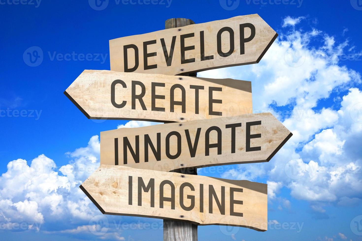 Develop, Create, innovate, Imagine - Wooden Signpost with Four Arrows, Sky with Clouds in Background photo
