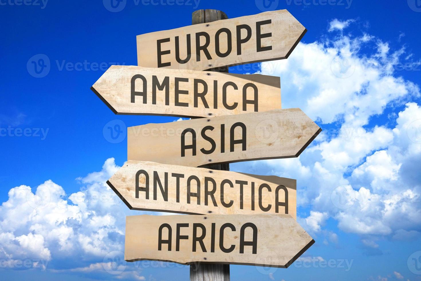 Europe, America, Asia, Antarctica, Africa - Wooden Signpost with Five Arrows photo