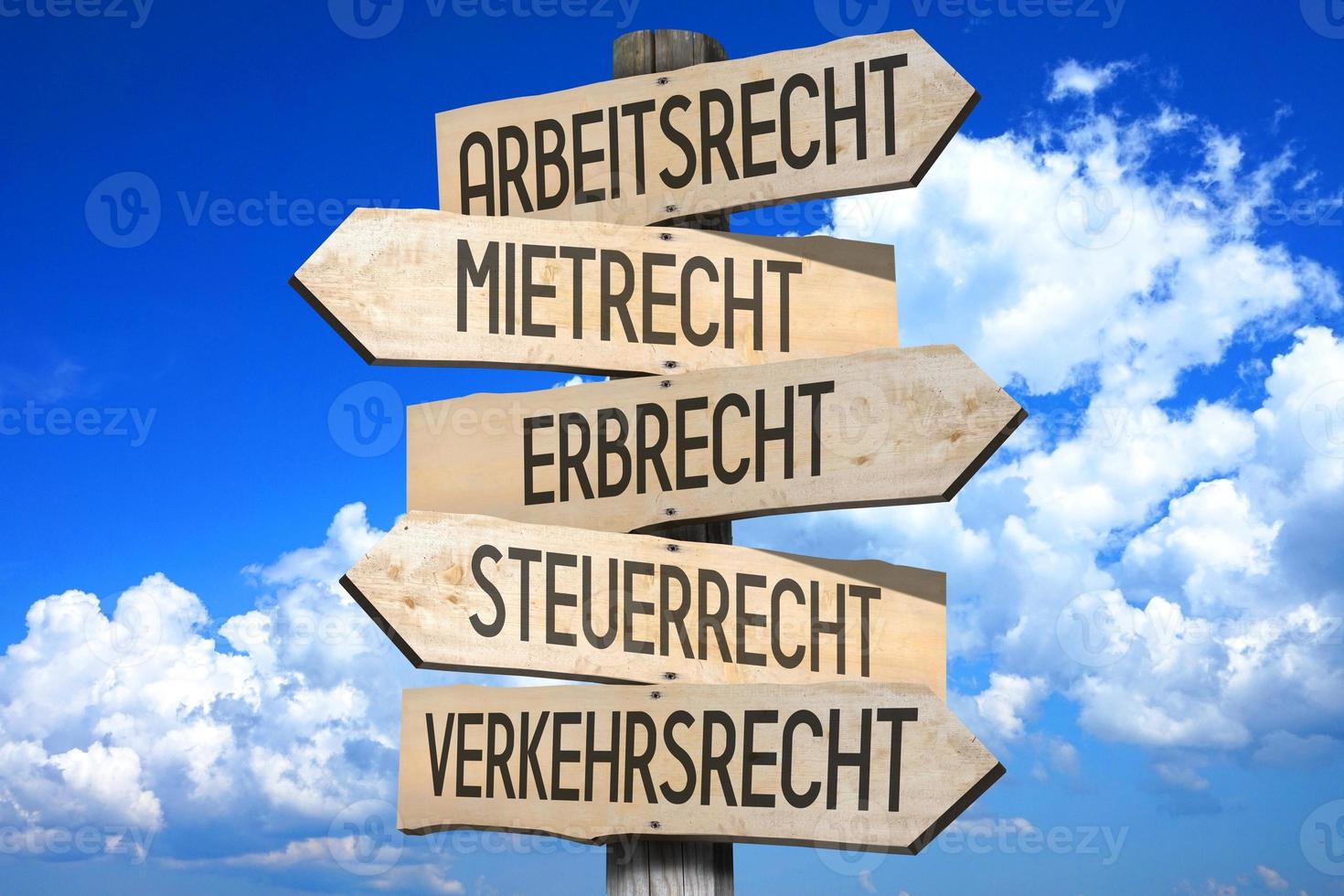 Law Concept in German - Wooden Signpost with Five Arrows, Sky with Clouds in Background photo