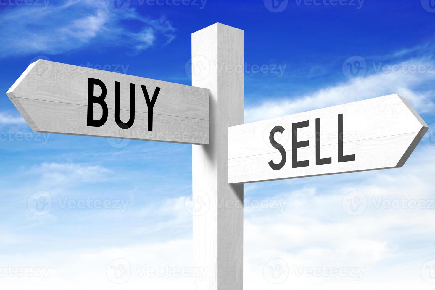 Sell, Buy - Wooden Signpost with Two Arrows and Sky in Background photo