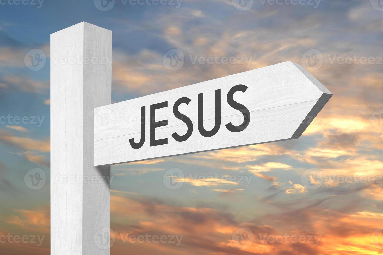 Jesus - White Wooden Signpost with one Arrow and Sunset Sky in Background photo