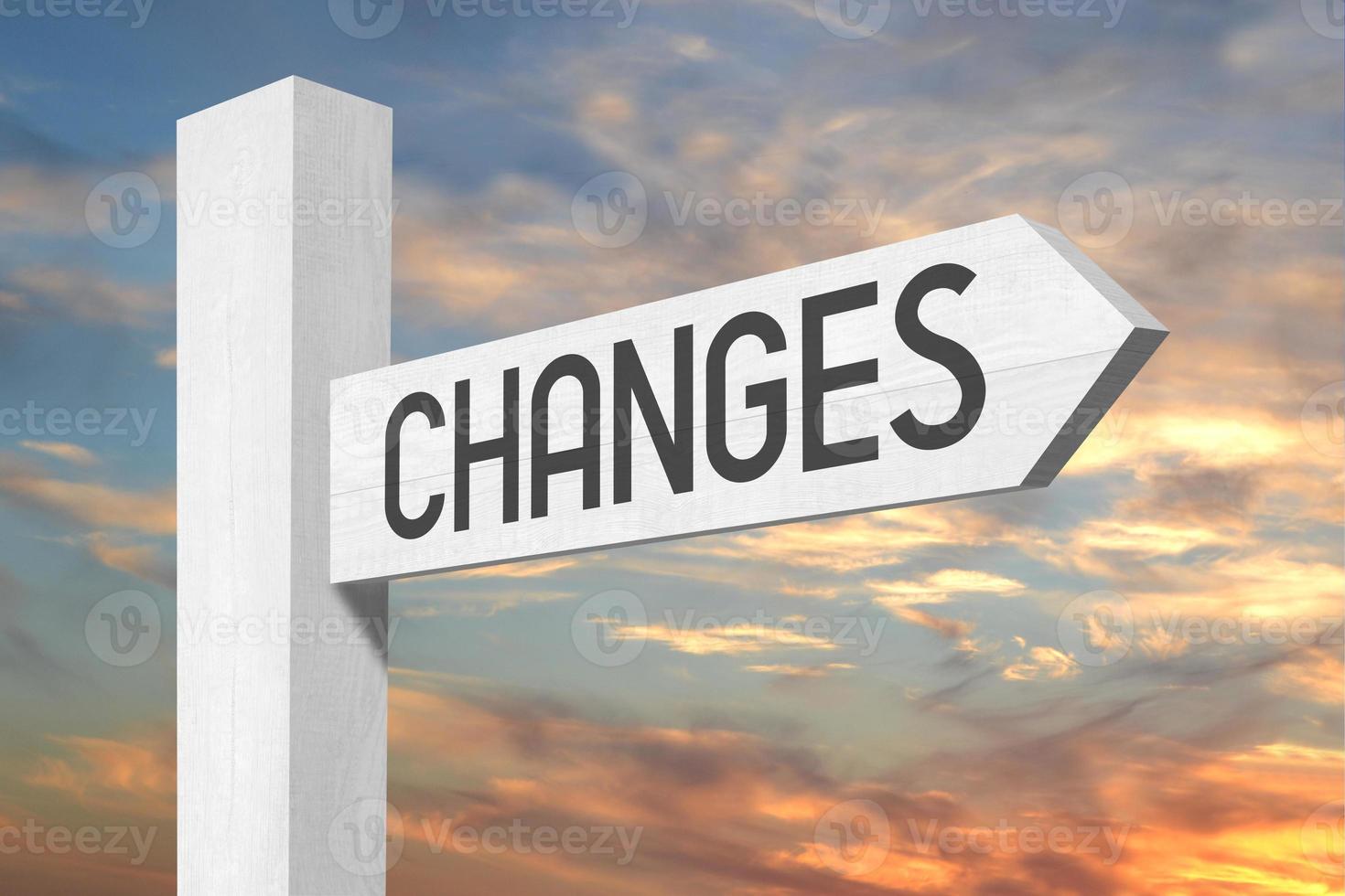 Changes Ahead - White Wooden Signpost with one Arrow and Sunset Sky in Background photo