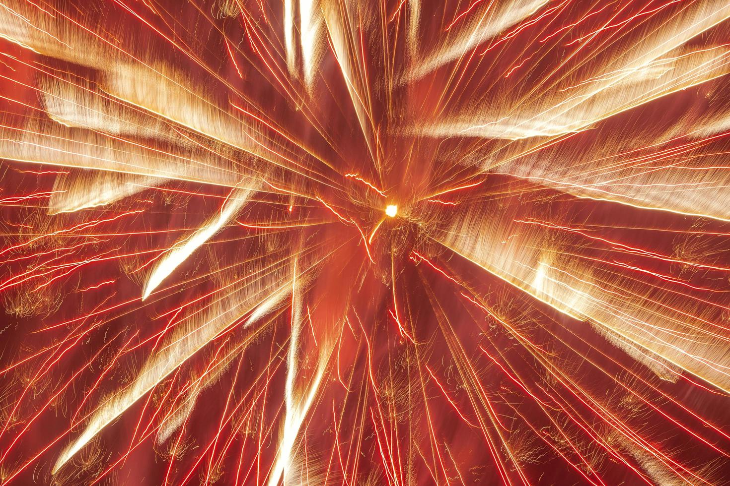 close up of bright firework burst against red background photo