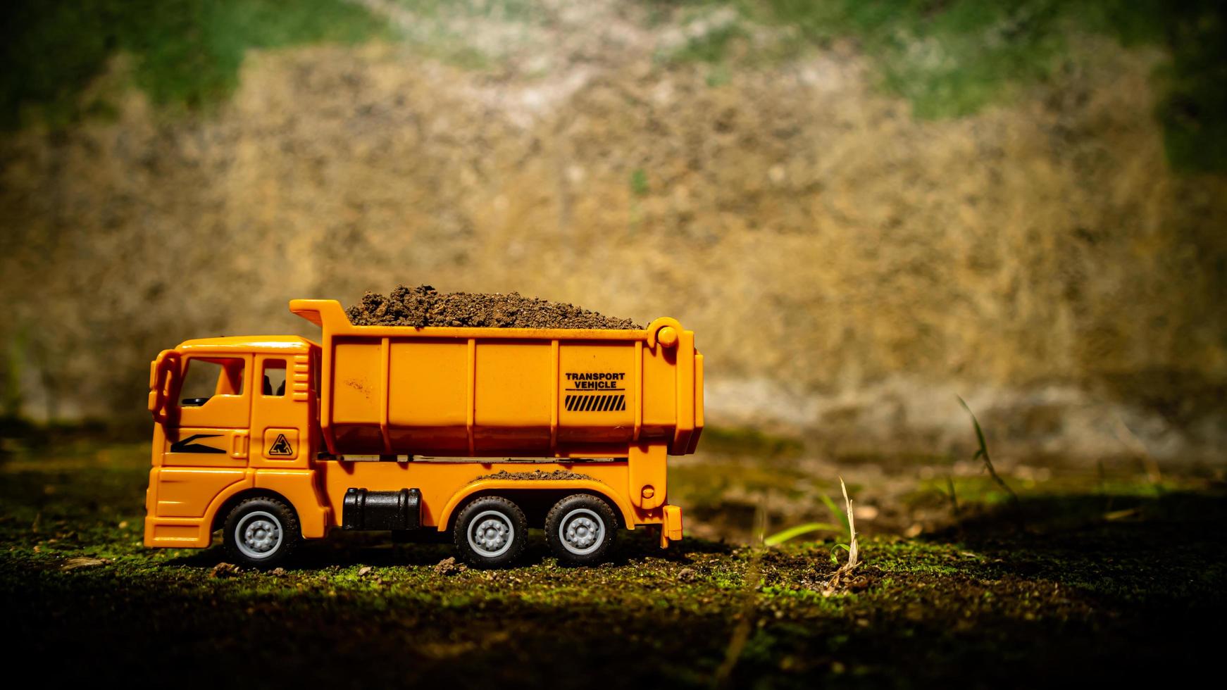 South Minahasa, Indonesia  January 2023, a yellow dump truck toy transporting sand photo