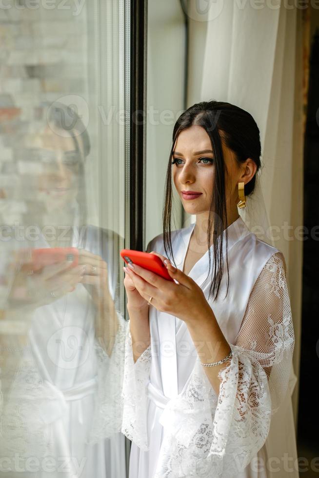 Portrait of happy bride holding cell phone photo