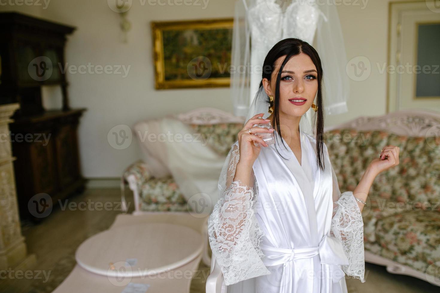 bride applying perfume on her wrist photo