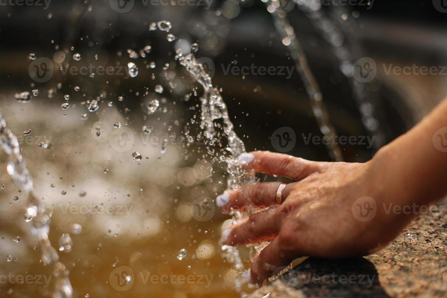 Hands with water splash, backlit by the evening sun. photo