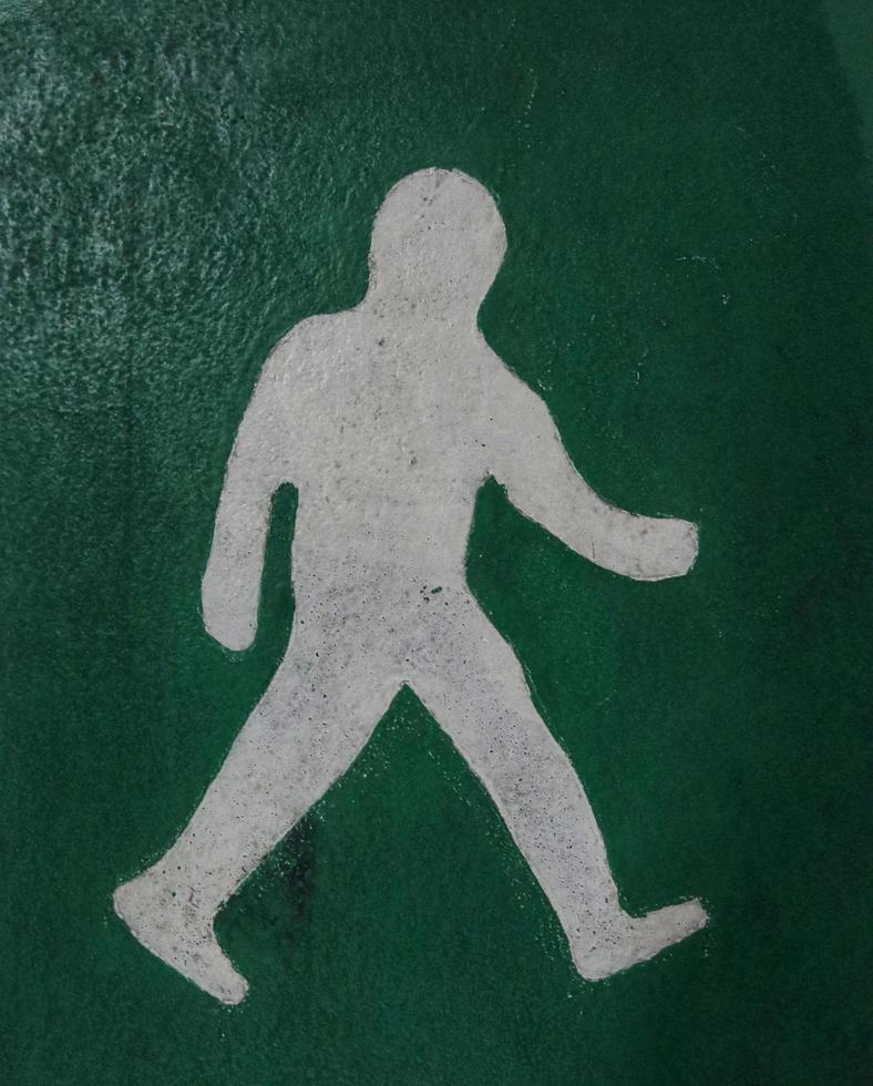 Green walking path sign on white.man icon photo