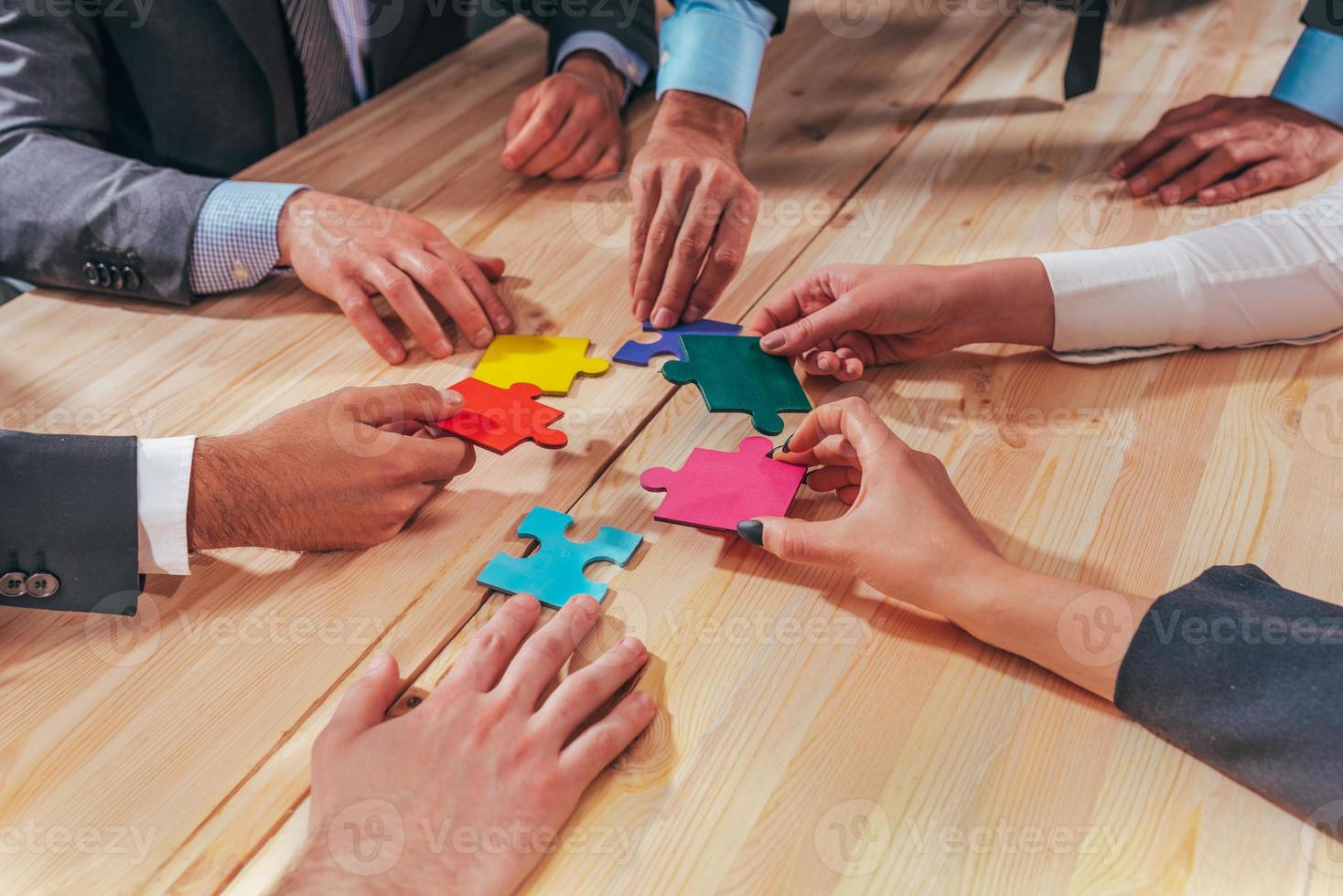 Business team connect pieces of puzzle like a teamwork and partners photo