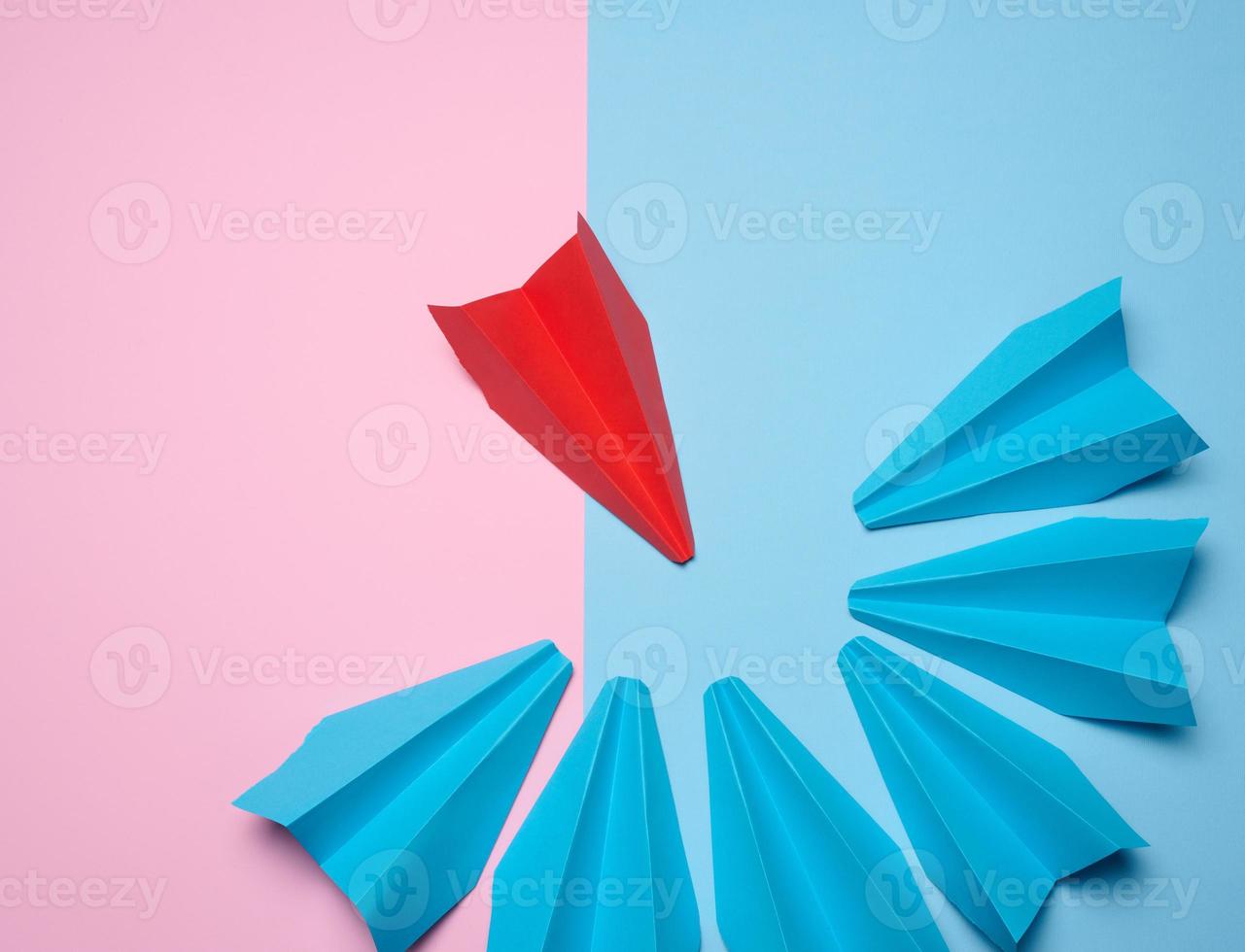un grupo de azul papel barcos rodeado uno rojo bote, el concepto de acoso, buscar para compromiso. parte superior vera grupo de azul papel avión rodeado uno rojo barco foto