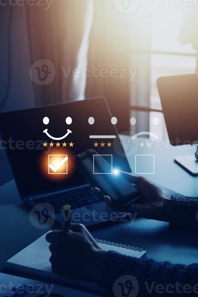 servicio al cliente y concepto de satisfacción, gente de negocios tocando la pantalla virtual en el icono de la cara feliz para dar satisfacción en el servicio. calificación muy impresionado. foto