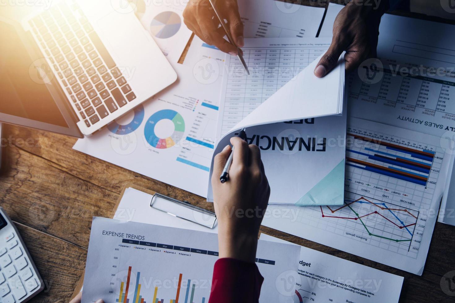 Group of confident business people point to graphs and charts to analyze market data, balance sheet, account, net profit to plan new sales strategies to increase production capacity. photo