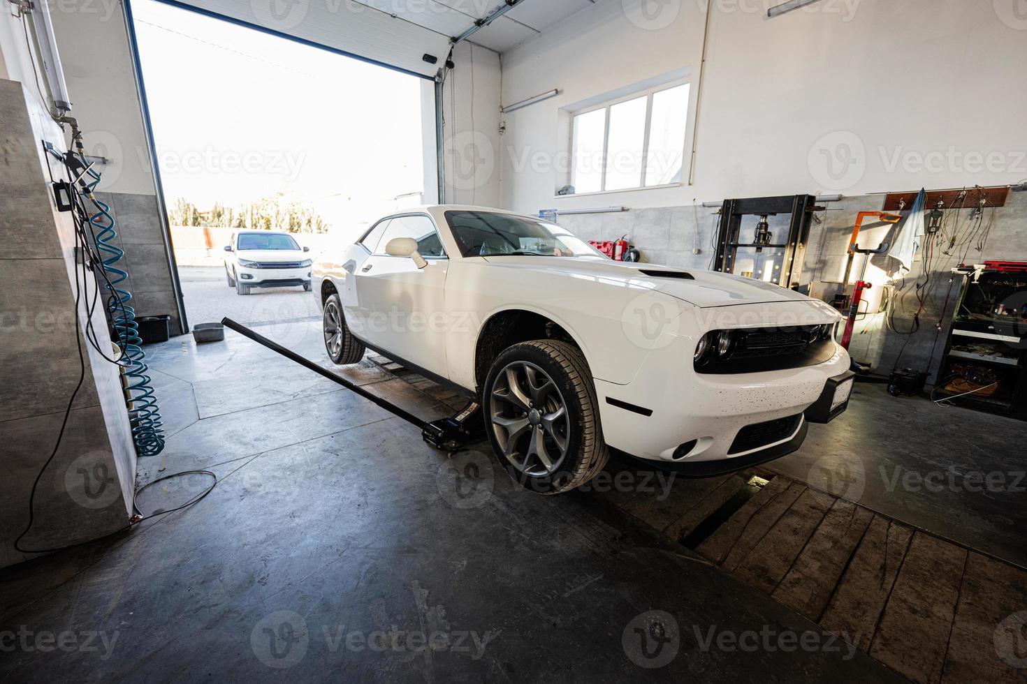 Muscle car at service repair station. Jacks up the car to diagnose the chassis. photo