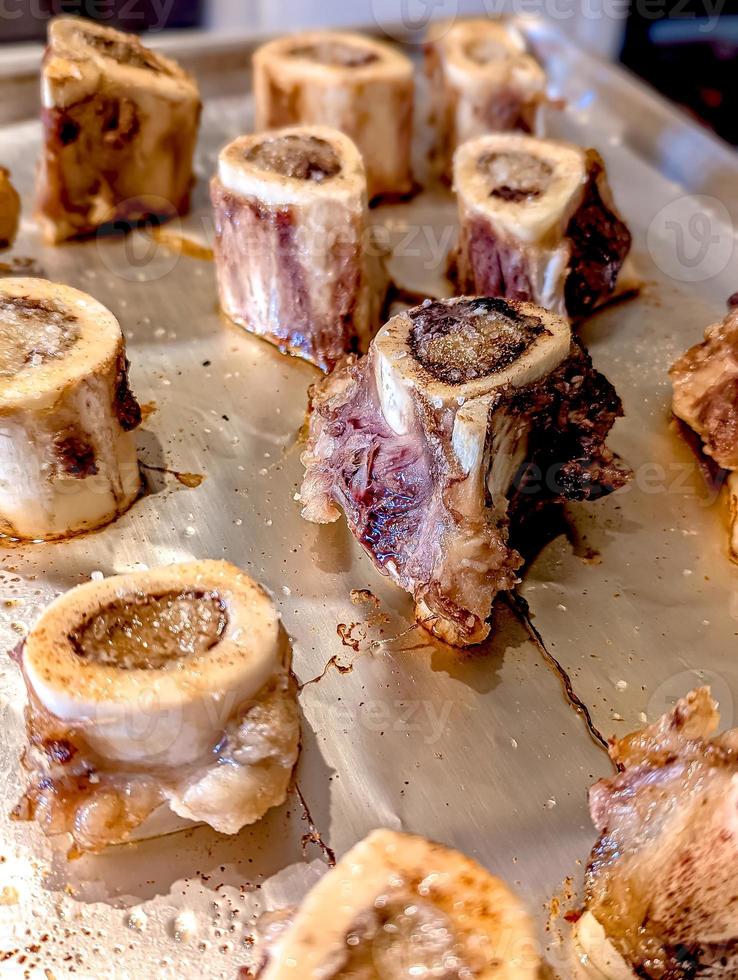 beef bone marrow pieces in the oven on a tray ready for a meal photo