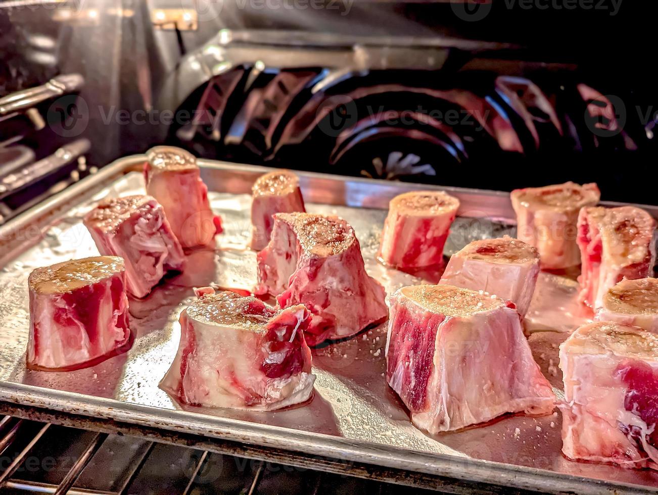 beef bone marrow pieces in the oven on a tray ready for a meal photo