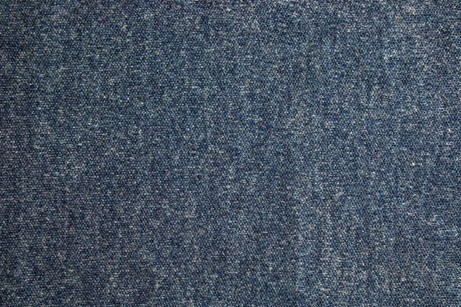 Texture of blue knitted fabric. Abstract modern knitted texture in blue color. Dark knitted background photo