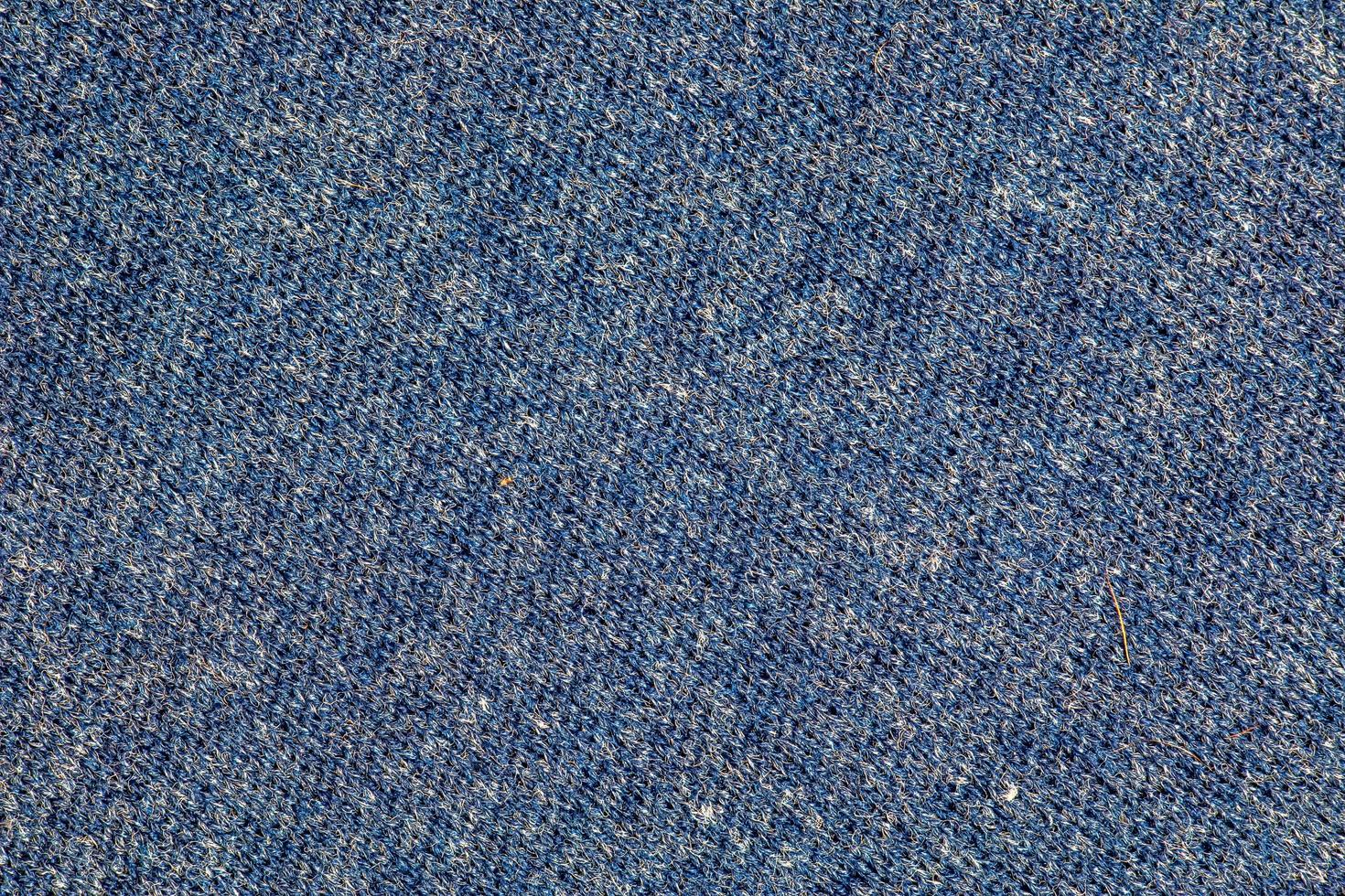 Texture of blue knitted fabric. Abstract modern knitted texture in blue color. Dark knitted background photo