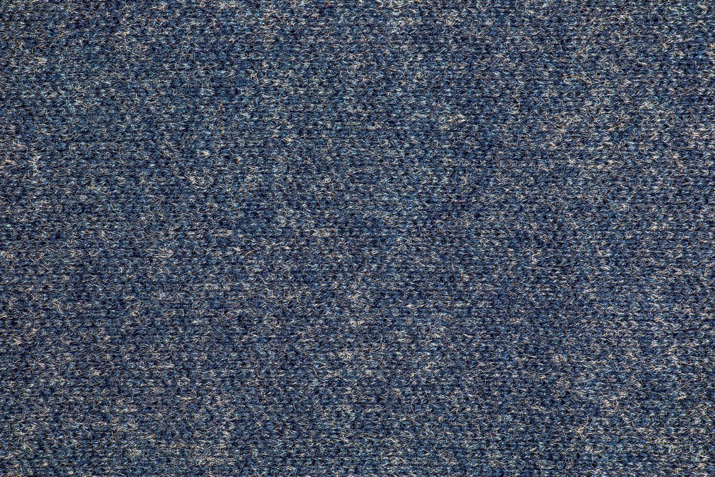 Texture of blue knitted fabric. Abstract modern knitted texture in blue color. Dark knitted background photo