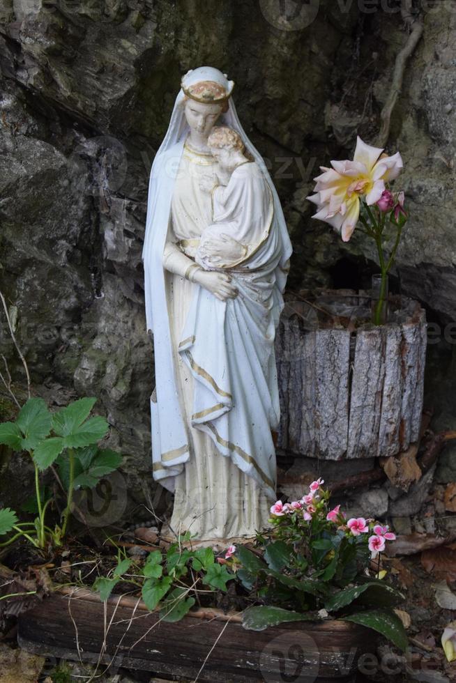 white statue of holy mary in the forest photo