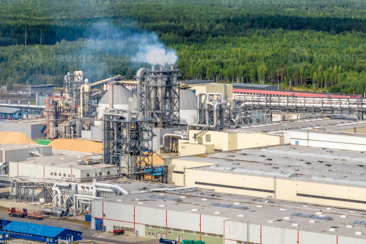 aerial panoramic view of city with a huge factory with smoking chimneys in the background photo