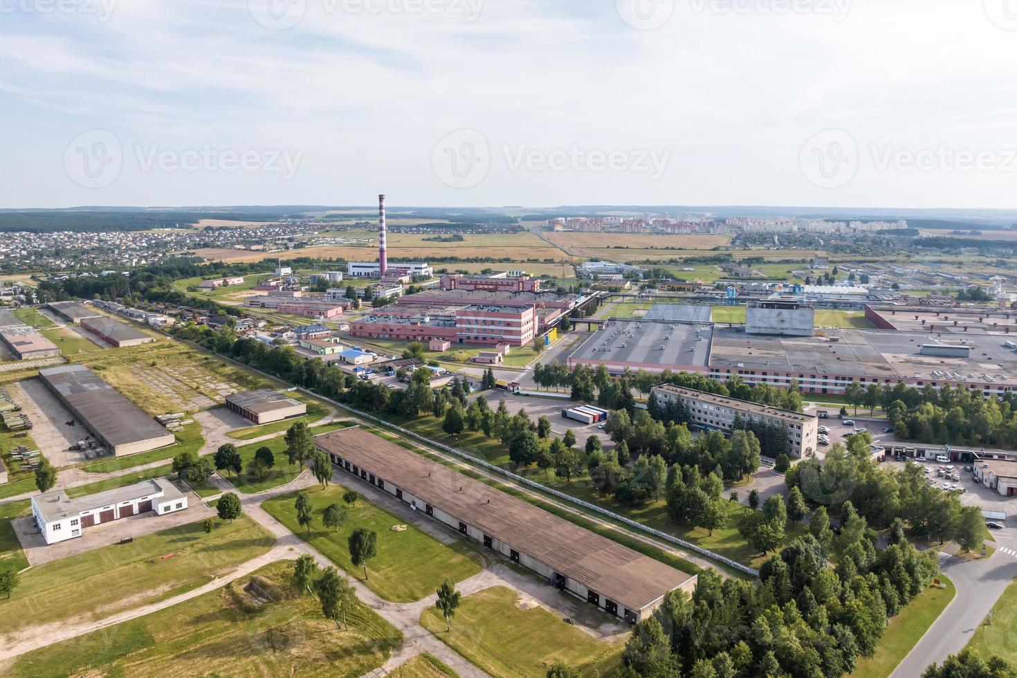 aerial panoramic view of city with a huge factory with smoking chimneys in the background photo