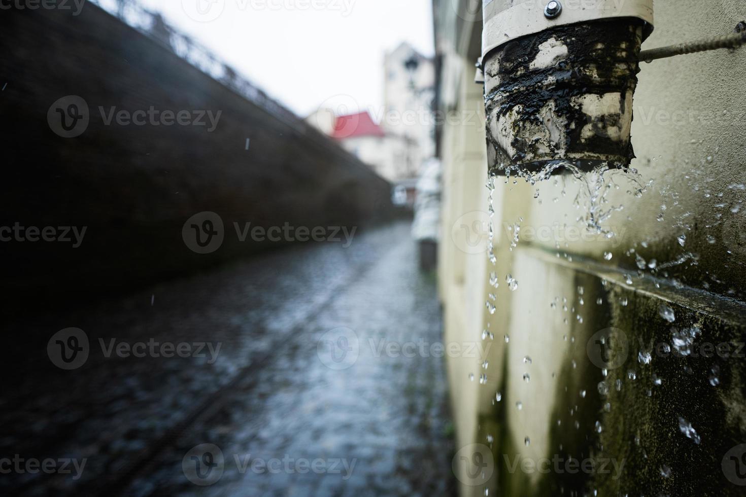 Rainwater flows down from the gutter. Mold on the wall. photo