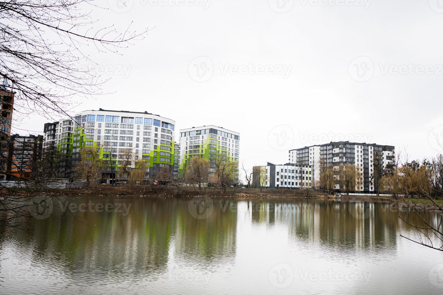 Modern residential multistory apartment buildings near lake. Facade of new houses. photo