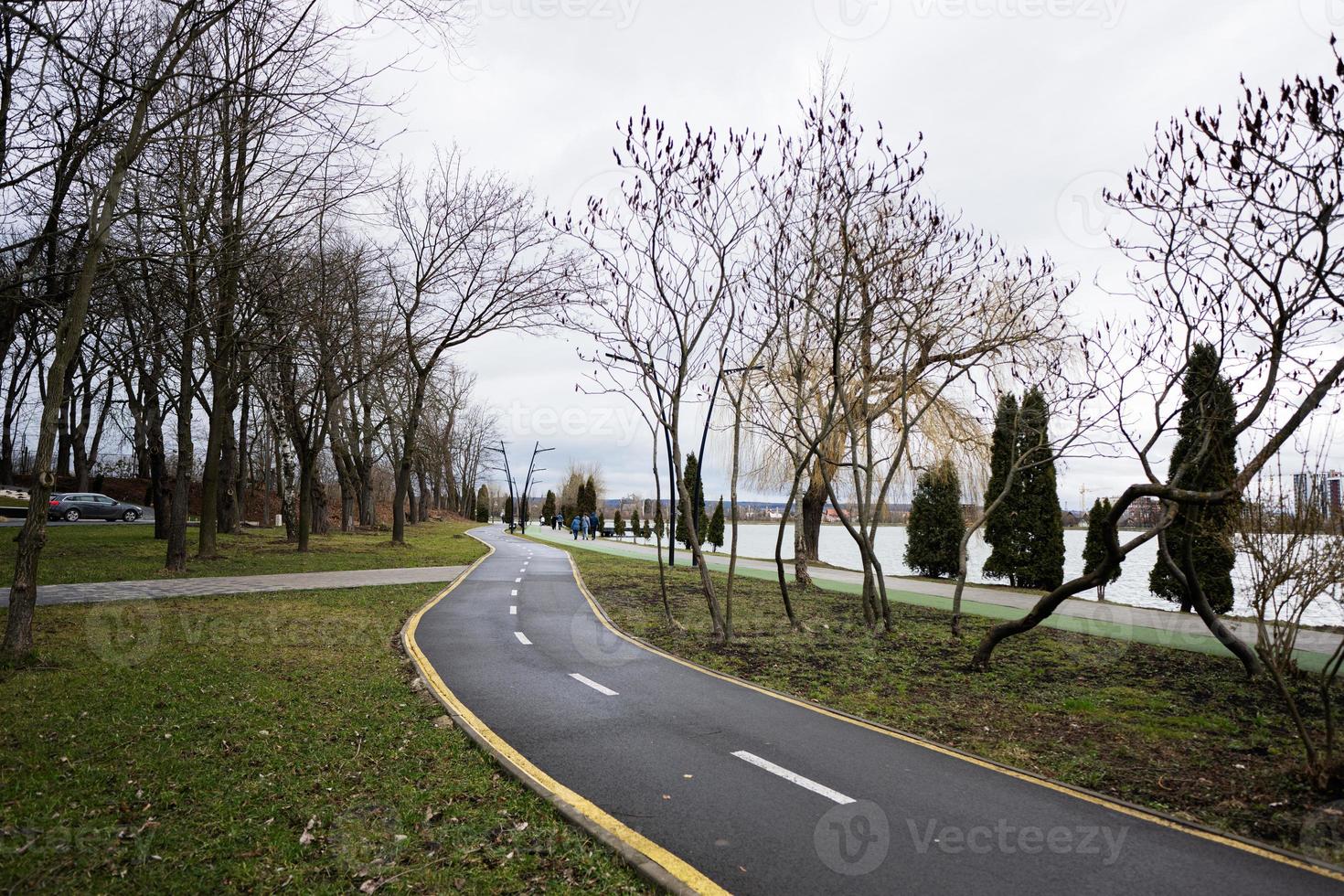 Running and cycling paths along the city alley embankment. Lake promenade. photo