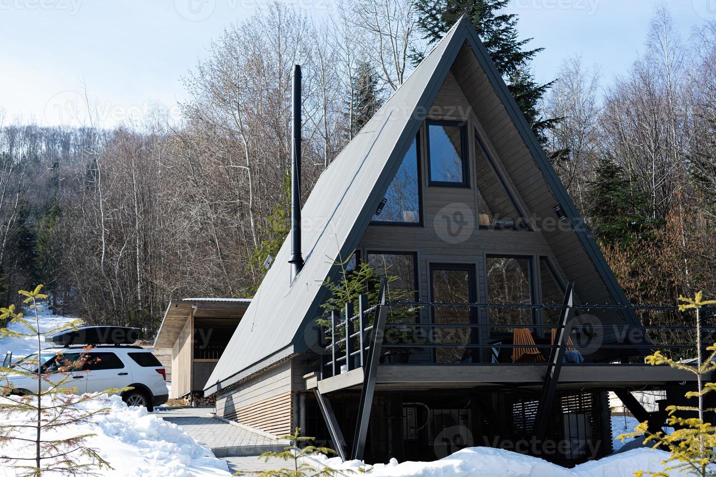 Wooden triangle country tiny cabin house and suv car with roof rack in mountains. Soul weekends. photo