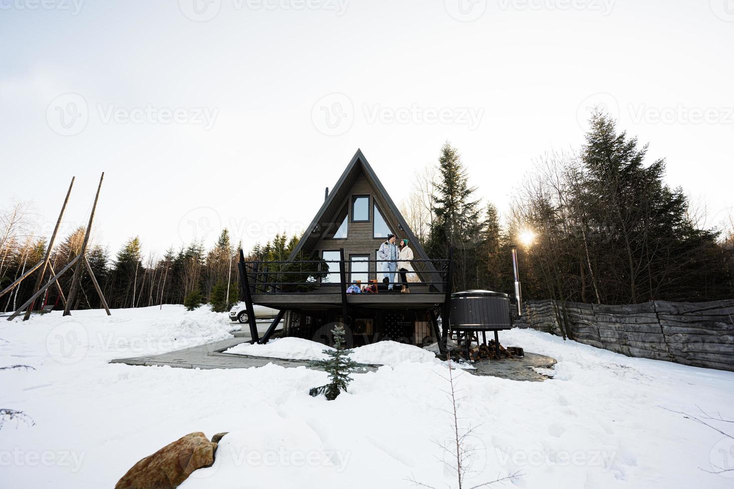 Family with two daughters on terrace off grid tiny house in the mountains. photo