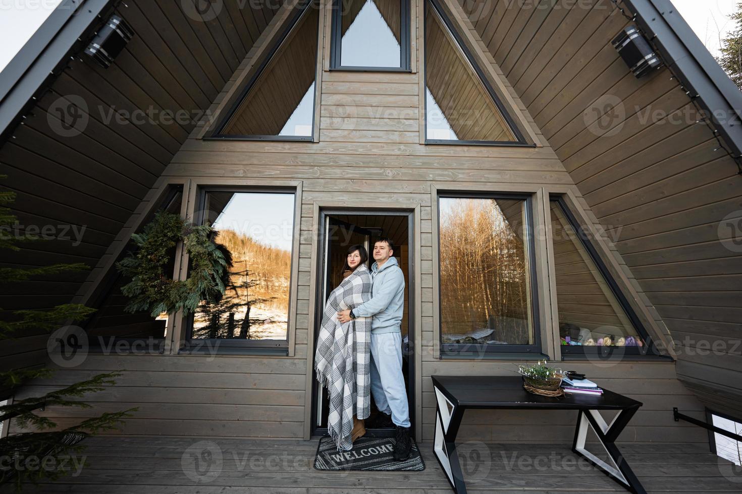 Pareja en amor en terraza apagado cuadrícula minúsculo casa en el montañas. foto