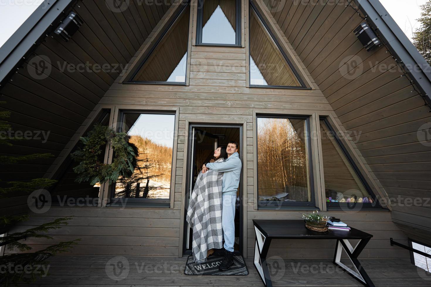 Pareja en amor en terraza apagado cuadrícula minúsculo casa en el montañas. foto