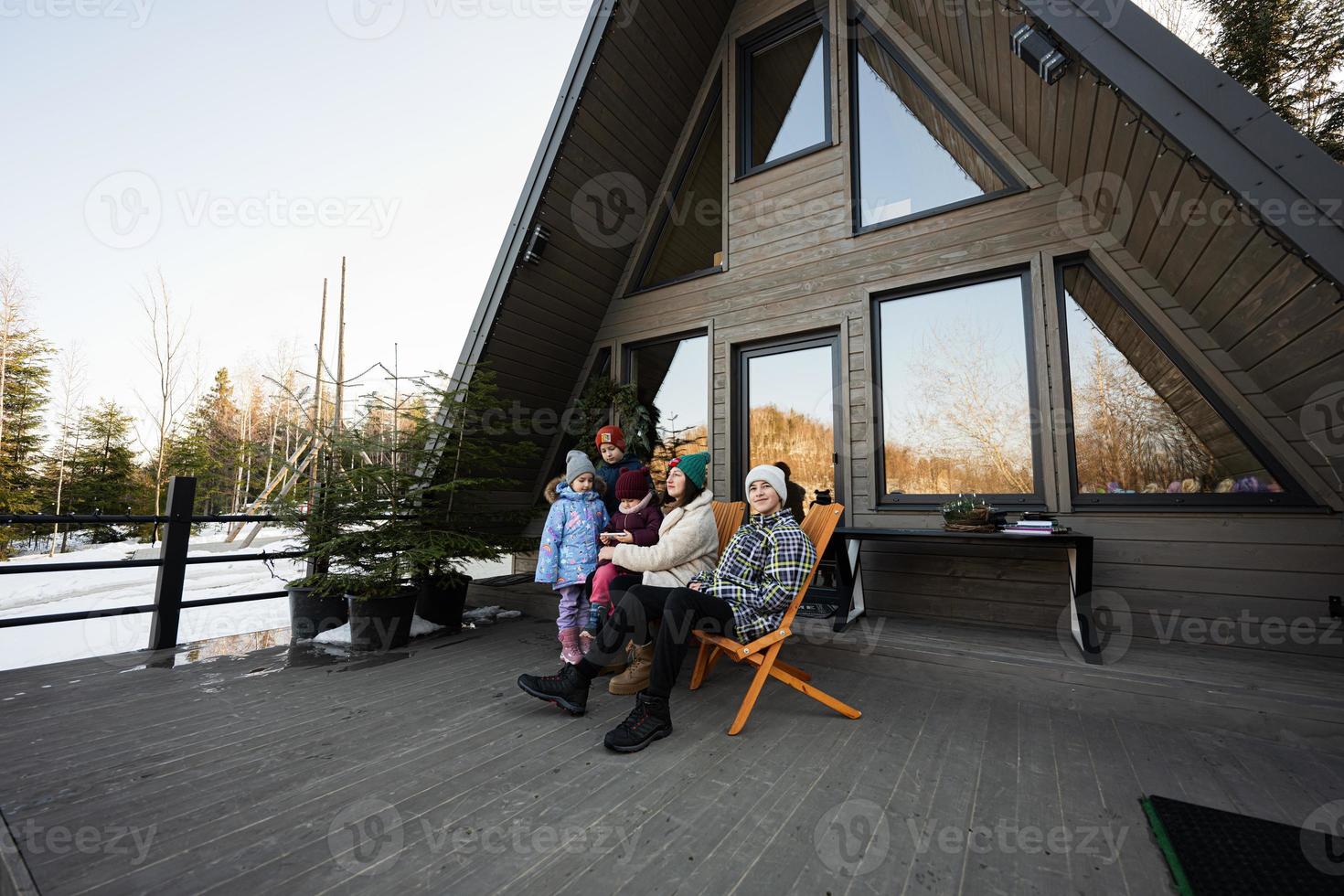 Mother with four children sit on terrace off grid tiny house in the mountains. photo