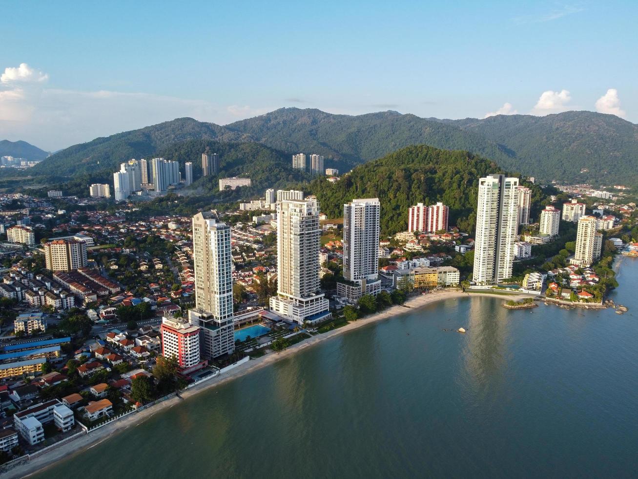 aéreo ver alto condominio a mar costero durante soleado día foto