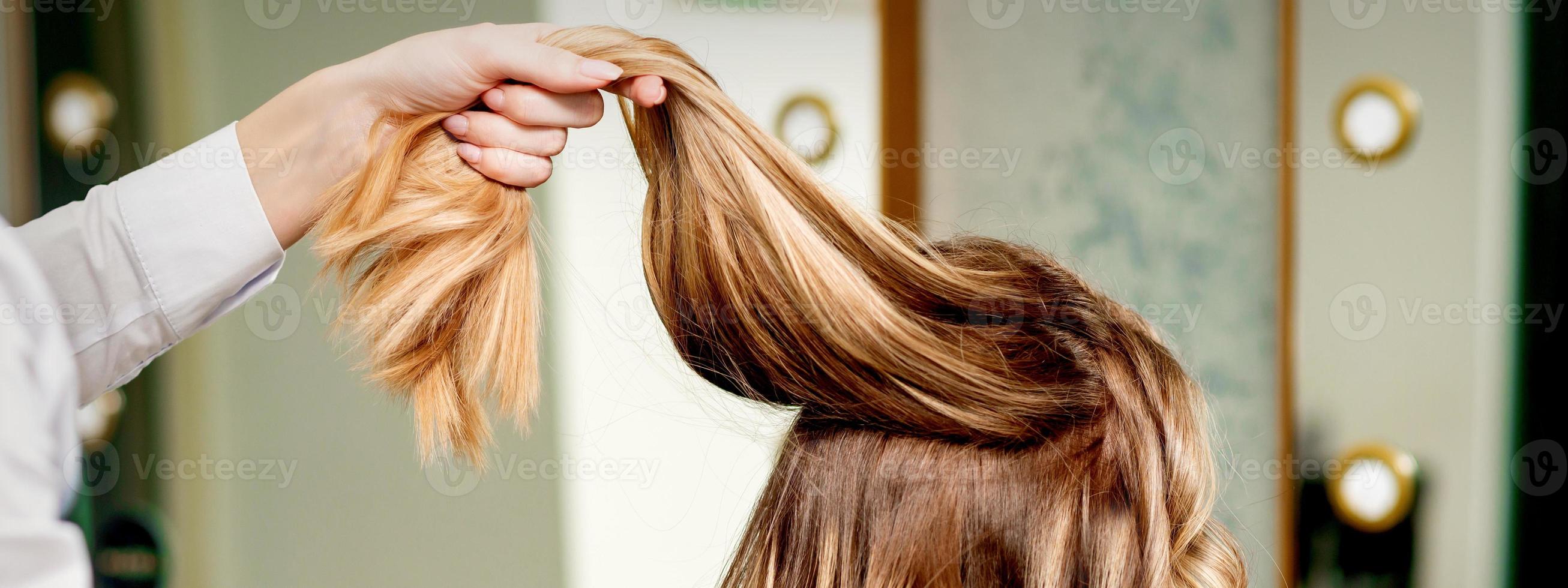 Hairdresser holds strand of hair photo